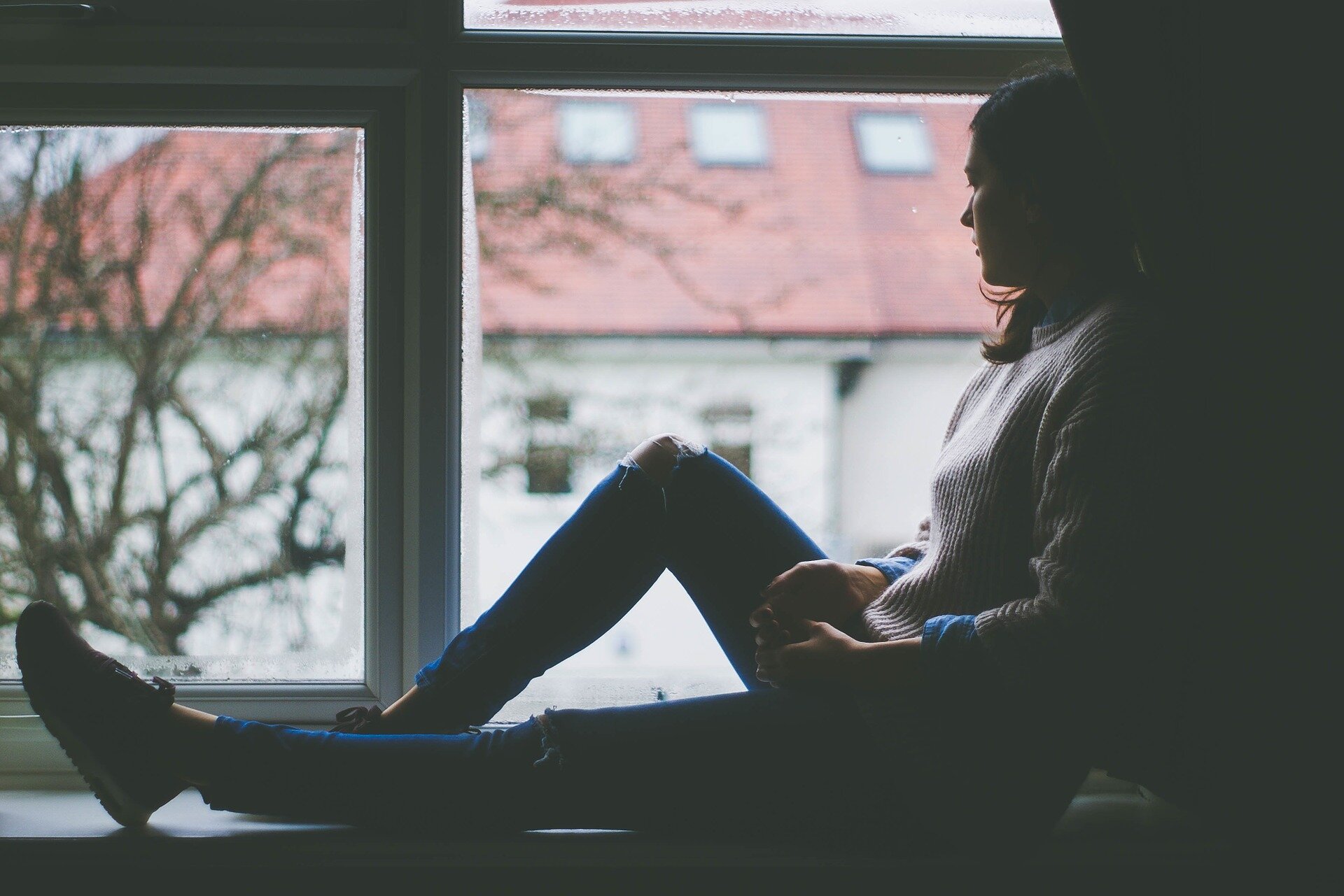 woman on window sill sad